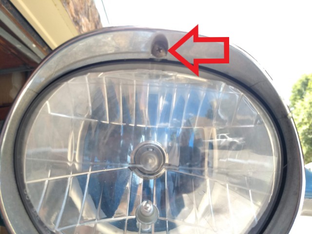 Remove the single screw securing the headlight ring then remove the ring.