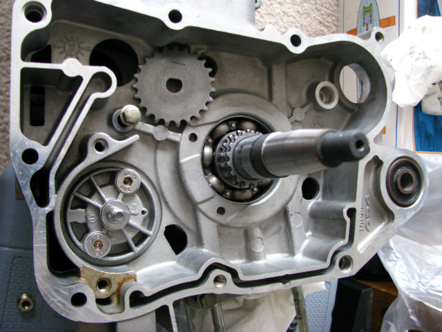 Oil pump, lower left corner. Note the arrow on the right side of the pump. This arrow should be pointed toward the top of the engine when installing, otherwise the oil channels of the pump won't match up with the case.