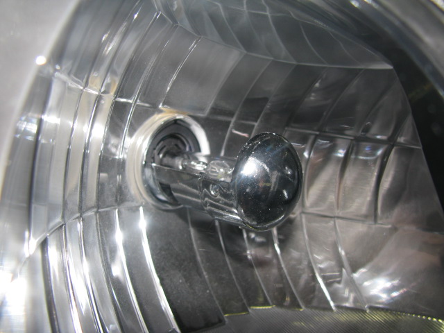 HID bulb inside the reflector showing the metal shield. Note the small opening in the bottom of the shield near the base of the bulb - that's for the high beam.